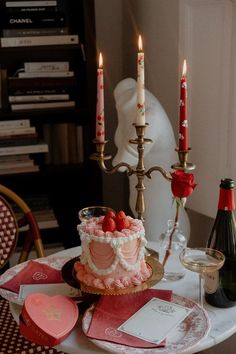 a table topped with a cake and two candles