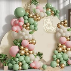 an arch made out of balloons and greenery