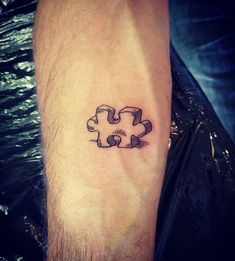 a person with a tattoo on their arm has a puzzle piece in the shape of a heart