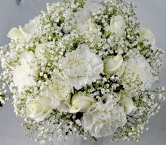 a bouquet of white flowers sitting on top of a table