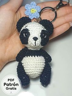 a crocheted panda bear keychain with a flower on it