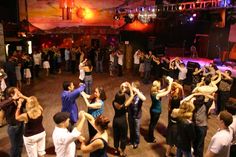 a group of people standing around each other on a dance floor