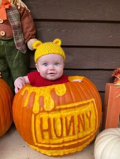 a baby sitting in a pumpkin shaped like a winnie the pooh