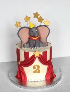 an elephant is sitting on top of a circus cake