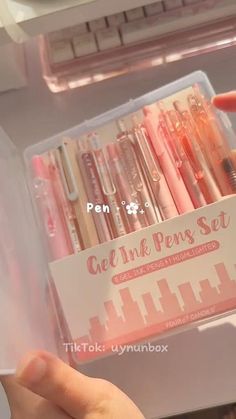 a person is holding a pen set in their hand and it's inside the box