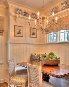 a dining room table with four chairs and a bowl of fruit on top of it