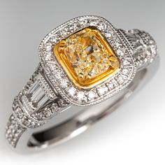 This well crafted ring is centered with one (1) cushion modified brilliant cut diamond set into a four-prong yellow gold accented setting. The ring is also accented with four (4) channel set tapered baguette cut diamonds, and seventy-two (72) bead set round brilliant cut diamonds. The ring measures 10.9mm at the top, rises 7.5mm above the finger, tapering to 2.6mm wide and 1.4mm thick at the base of the shank.  It is crafted in 18k white gold and is currently a size 7.25. Classic Yellow Diamond Ring With Accents, Formal Yellow Cushion Cut Diamond Ring, Elegant Yellow Baguette Cut Diamond Ring, Gia Certified Classic Yellow Diamond Ring, Elegant Yellow Diamond Ring With Single Cut Diamonds, Elegant Yellow Square Cut Rings, Classic Yellow Diamond Ring Baguette Cut, Classic Yellow Baguette Cut Diamond Ring, Classic Yellow Diamond Ring For Formal Occasions