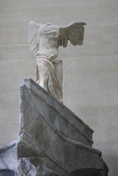 an angel statue sitting on top of a rock