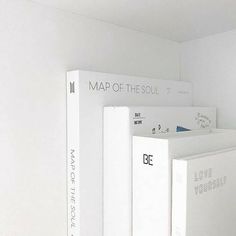 three books are stacked on top of each other in a room with white walls and flooring