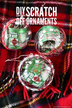 three christmas baubles are sitting on a plaid blanket