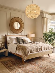 a bedroom with a large bed and a round mirror on the wall above it's headboard