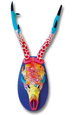 a colorful animal head with long horns and spots on it's face, painted in bright colors