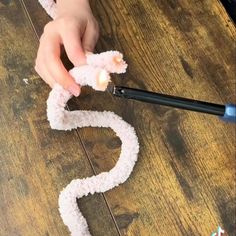 someone is making a paper snake out of yarn