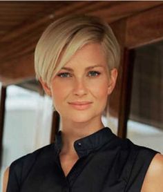 a woman with blonde hair and blue eyes wearing a black shirt is smiling at the camera