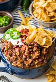 chili and cheese dip in a blue pot with tortilla chips on the side