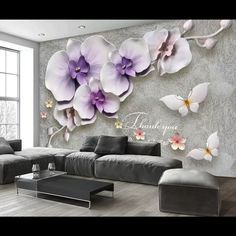 a living room with flowers on the wall and a large couch in front of it