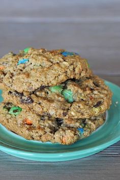 two cookies stacked on top of each other on a blue plate with green and white sprinkles