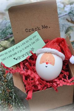 an egg with a santa hat in a cardboard box