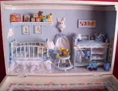 a doll's house with furniture and accessories in the box, including a crib