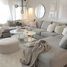 a living room filled with lots of furniture and pillows on top of a white rug