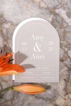 an orange flower sitting on top of a white grave marker with the word and date printed on it