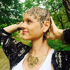 a woman with henna on her head in the woods