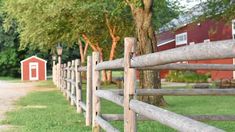 a wooden fence in front of a red barn