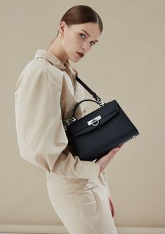 Inspired by Grace Kelly's enduring style, the Grace Top Handle Bag is meticulously crafted from premium USA full-grain textured calfskin leather, ensuring both durability and elegance. Its timeless and versatile design features a thoughtfully structured interior that comfortably accommodates all your everyday essentials. Whether day or night, you'll find yourself instinctively reaching for this chic and easy-to-wear masterpiece. Luxury Traditional Shoulder Bag With Top Carry Handle, Luxury Classic Flap Bag With Metal Hardware, Luxury Designer Top Handle Flap Bag, Luxury Taupe Shoulder Bag With Palladium Hardware, Luxury Top Handle Flap Bag, Luxury Flap Bag With Adjustable Strap For On-the-go, Luxury Top Handle Flap Bag With Palladium Hardware, Luxury Handheld Satchel With Silver-tone Hardware, Elegant Soft Leather Bags