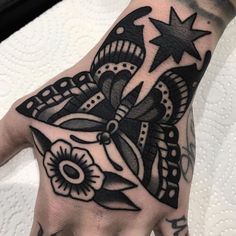 a person's hand with a black and white tattoo on it