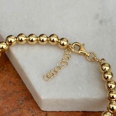 14KT yellow gold rounded bead/ ball chain link bracelet. Great, interesting links bracelet to wear on its own or with an arm full of bracelets! Length: 7" with 1" extender to 8" Shown on a 6" wrist Chain width: 5mm Weight: 3.40 grams Stamped 14K Lobster clasp Hollow balls Everyday Gold Ball Chain Beaded Bracelets, Gold Beaded Bracelets With Ball Chain, Gold Beaded Bracelets With Ball Chain For Everyday, Everyday Gold Beaded Bracelets With Ball Chain, Adjustable Ball Chain Beaded Bracelet For Gift, Adjustable Ball Chain Beaded Bracelets As Gifts, Adjustable Beaded Bracelet With Ball Chain For Gifts, Gold Adjustable Ball Chain Bracelet, Gold Ball Chain Bracelet For Everyday