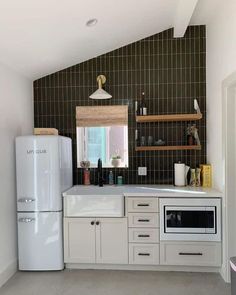 a white refrigerator freezer sitting inside of a kitchen next to a counter top oven