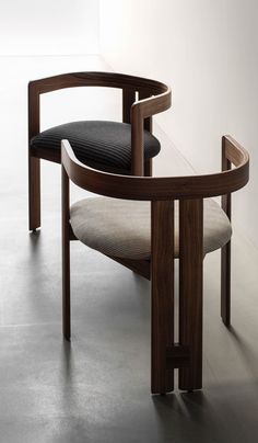 a wooden chair with black and white cushion on it's seat, next to a glass table