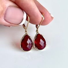 Red Quartz Earrings, January Birthstone, Dark Red Teardrop Earrings in Gold Filled, Deep Red Prong Set Fancy Jewelry, Holiday Gift for women These small but gorgeous earrings feature deep Red Quartz teardrops bezel framed in gold filled. The deep red teardrops are suspended from lever back ear wires in the finish gold filled. These are small, delicate and dainty earrings but with a gorgeous vivid scarlet color sure to match many outfits. Ideal for a girl or a women that likes strong vivid colors. These are elegant and classy and light on the ears. About This Earrings: - Gemstone: Red Quartz - Birthstone: January  - Stone Size: 12 mm x 10 mm - Earrings Size: 15mm x 8mm - Finish: Gold Filled - Gift wrapping included with all orders - Handmade at our home studio Processing Time: 1 Day To visi Infinite Jewelry, Gold And Red Earrings, January Stone, Scarlet Color, Classy Earrings, Red Quartz, Jewelry Holiday, Earrings Gemstone, January Birthstone