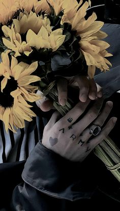 a person holding a bouquet of sunflowers in their hands