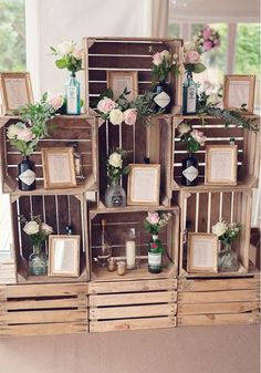 a bunch of wooden crates with flowers and pictures on them are stacked up in order to be decorated