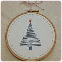 a hand embroidered christmas tree ornament hanging on a wall