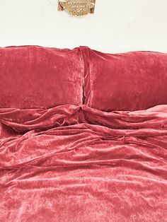 a red bed with two pillows and a gold emblem on the wall