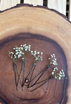 small white flowers are placed in the center of a piece of wood