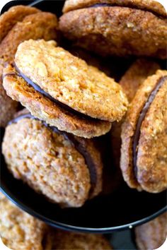 some cookies are stacked on top of each other in a black bowl and ready to be eaten