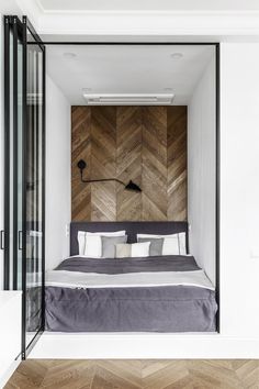 a bed sitting inside of a bedroom next to a wooden wall