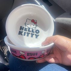 someone is holding two hello kitty bowls in their hand, with the words hello kitty on them