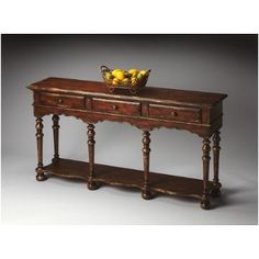 an old wooden table with two drawers and a bowl of fruit on it's top