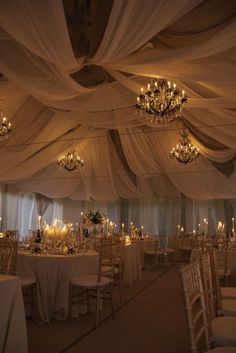 a banquet hall with chandeliers, tables and chairs