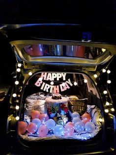 the back of a car is decorated with balloons and lights