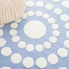 a blue rug with white circles on it and a ball of yarn next to it