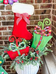 a basket filled with christmas decorations next to a brick wall and stockings on the fireplace