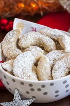 a white bowl filled with powdered sugar cookies