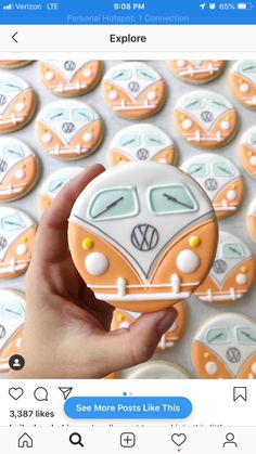 someone is holding up a cookie shaped like a vw camper van in front of some cookies