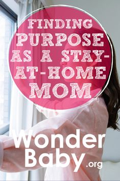 a woman in pink shirt standing next to window with text reading finding purpose as a stay at home mom