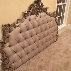 an ornate headboard in a bedroom with carpeted flooring and beige colored walls